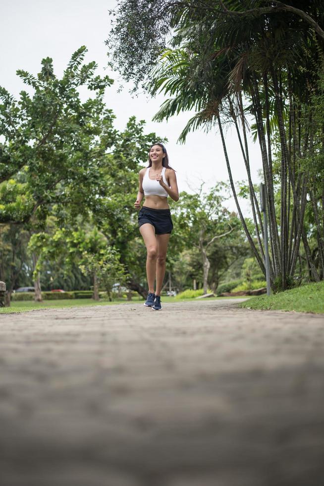 junge sportliche Frau, die im Park läuft foto