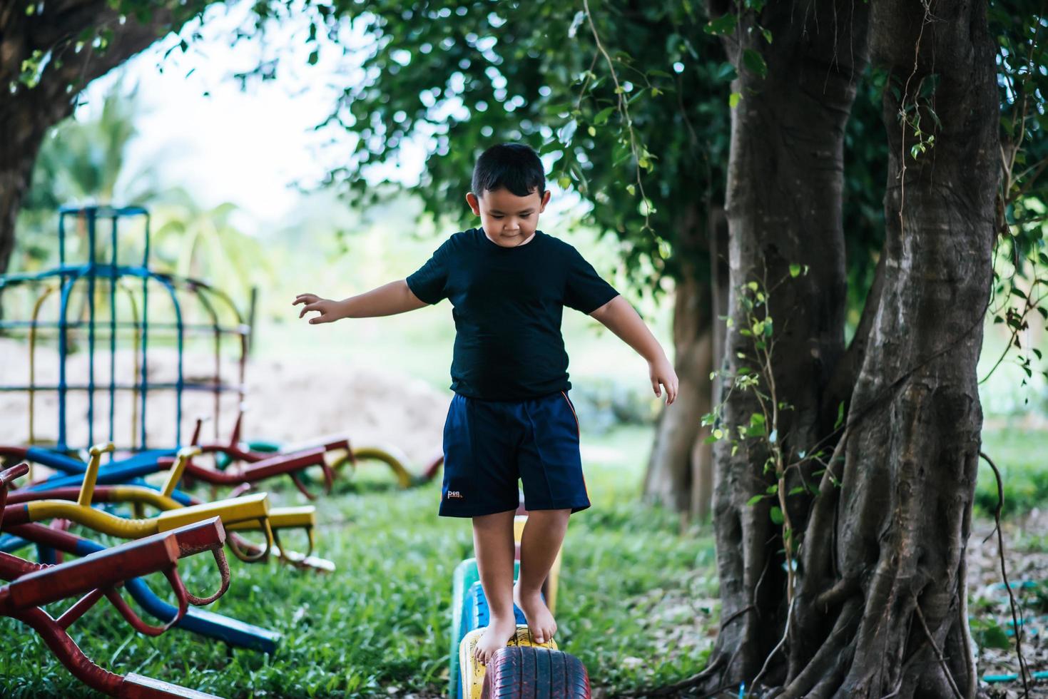 Kind läuft auf Reifen auf dem Spielplatz foto
