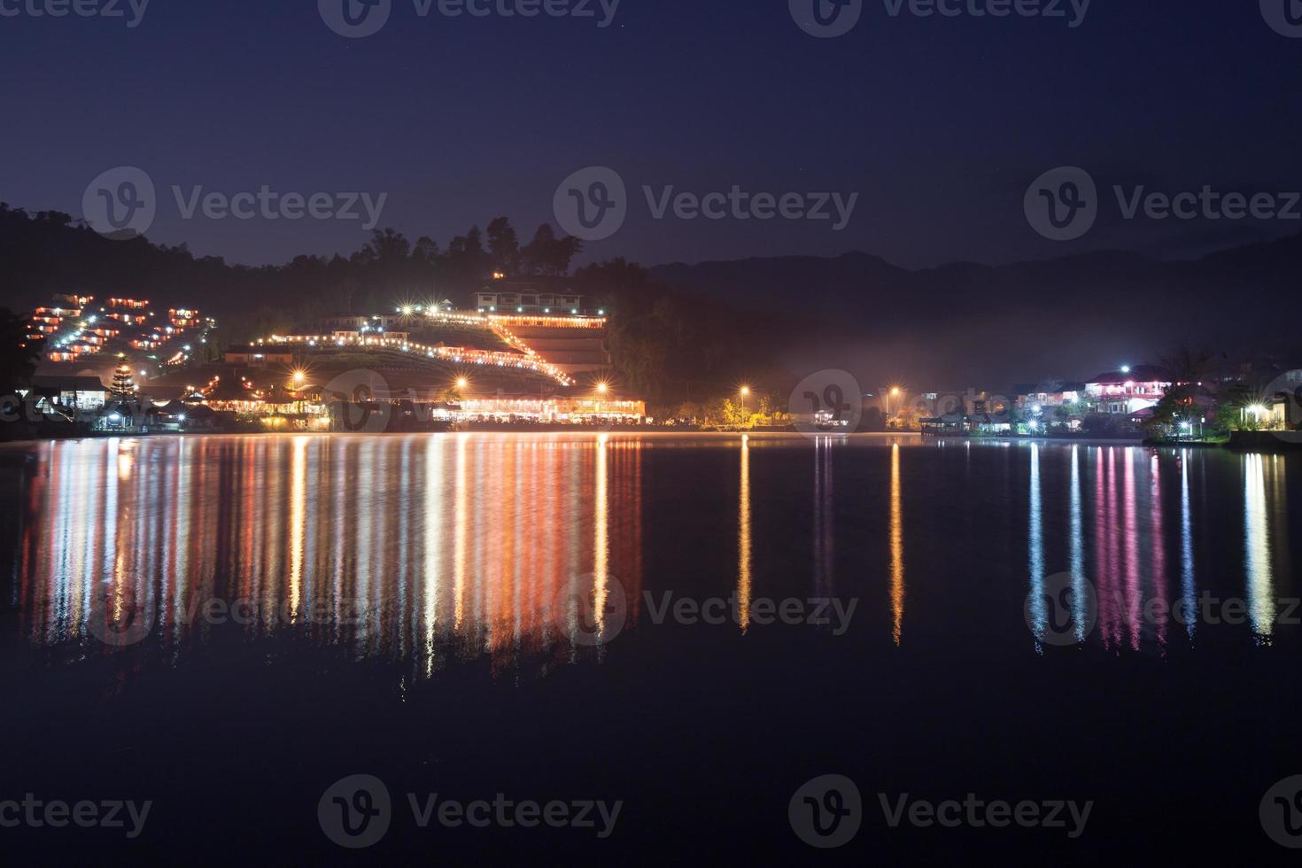 bunte Dorflichtreflexion auf Wasser foto