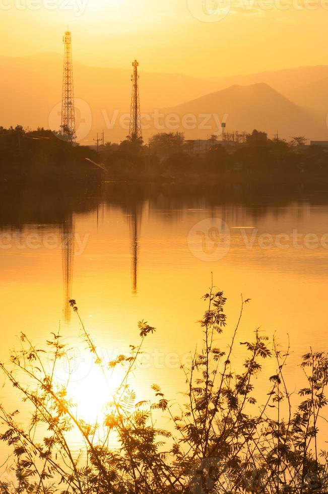 Sonnenuntergang auf das See im neblig mit Elektrizität Linien im Hintergrund foto