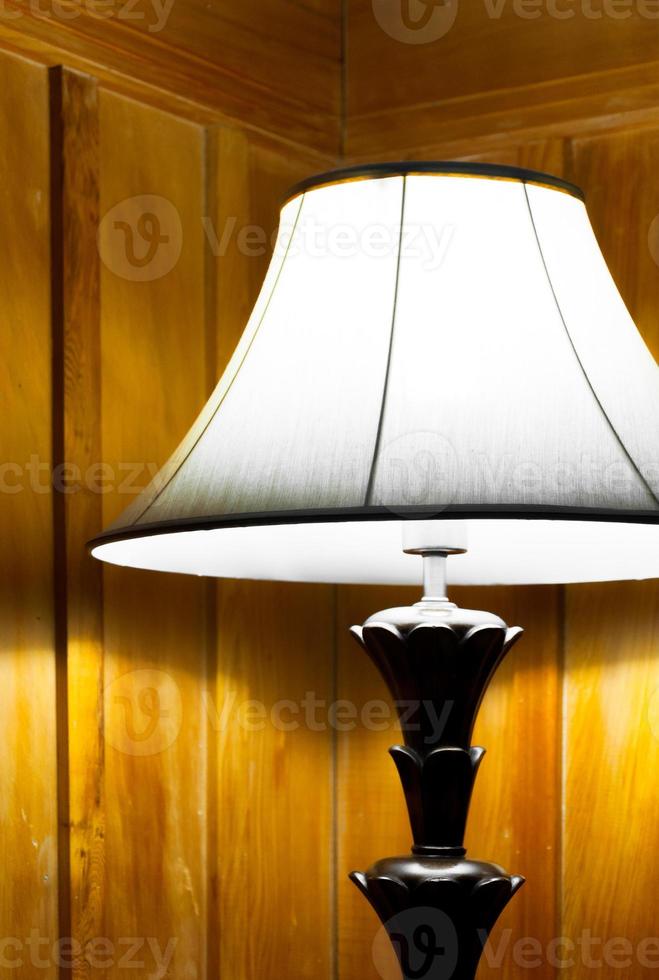 elegant Lampe im warm Innere Zimmer, drehte sich um auf alt Lampe in der Nähe von das hölzern Mauer foto