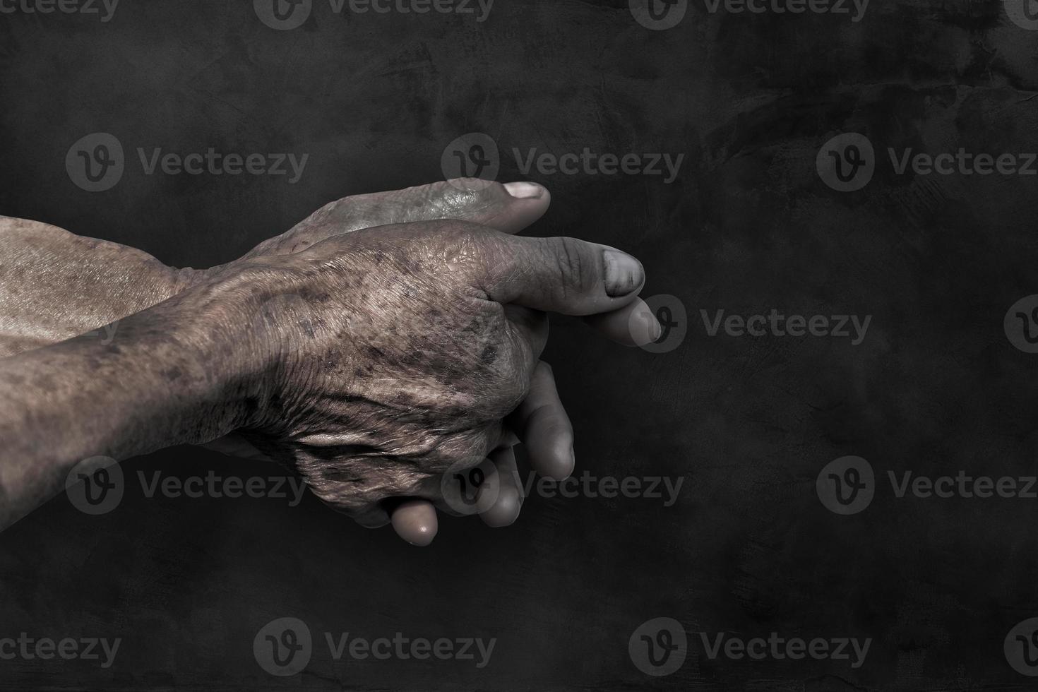Senior alt Hände und Arme.Finger und Nägel mit Venen. faltig Haut von alt Person. Altern Prozess.Hand schmutzig von Arbeiter nach Arbeiten auf dunkel Hintergrund foto