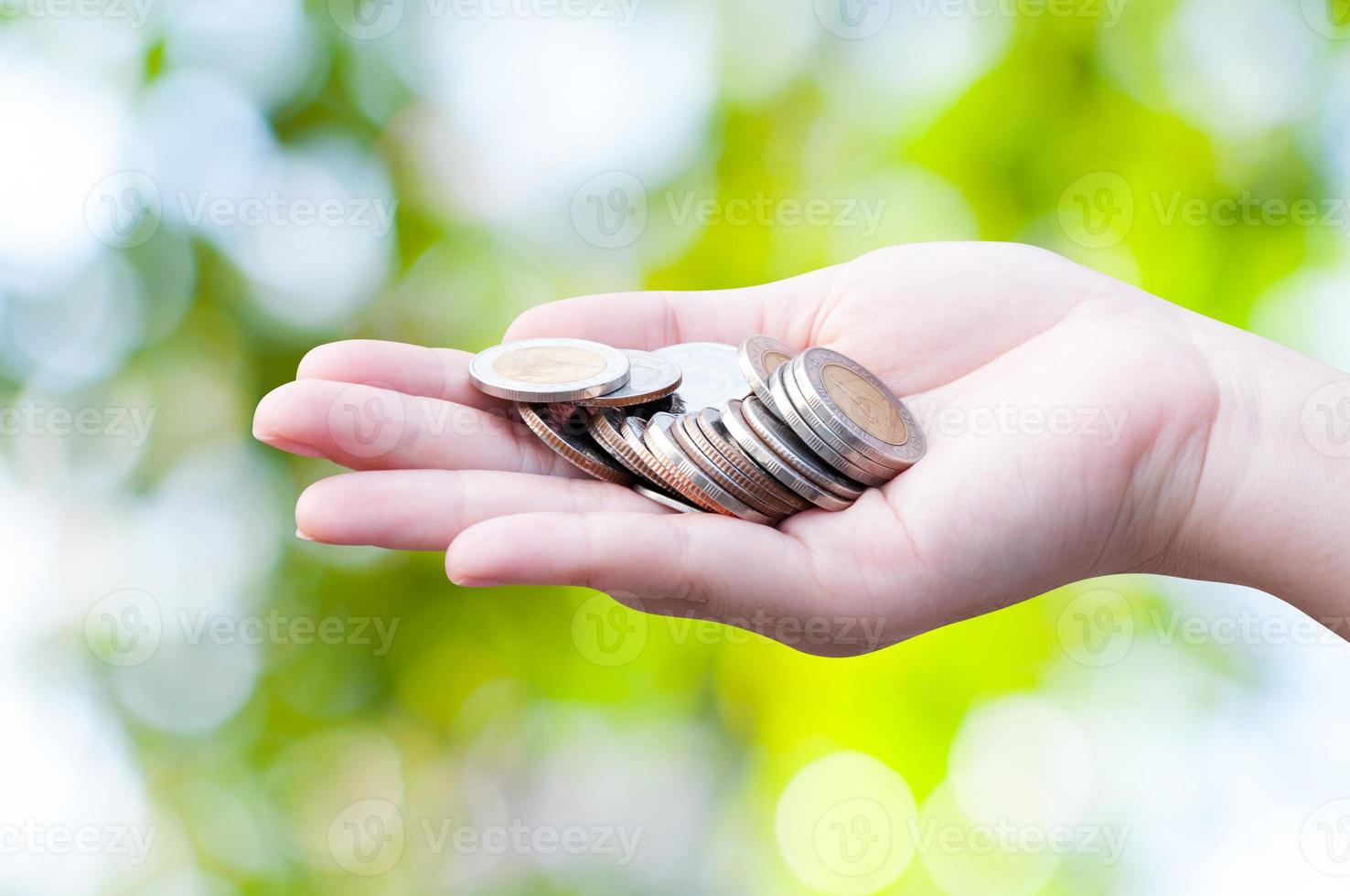 Münzen im Hände auf Grün Natur Hintergrund, Spende Investition Fonds finanziell Unterstützung Nächstenliebe Dividende Markt Wachstum foto