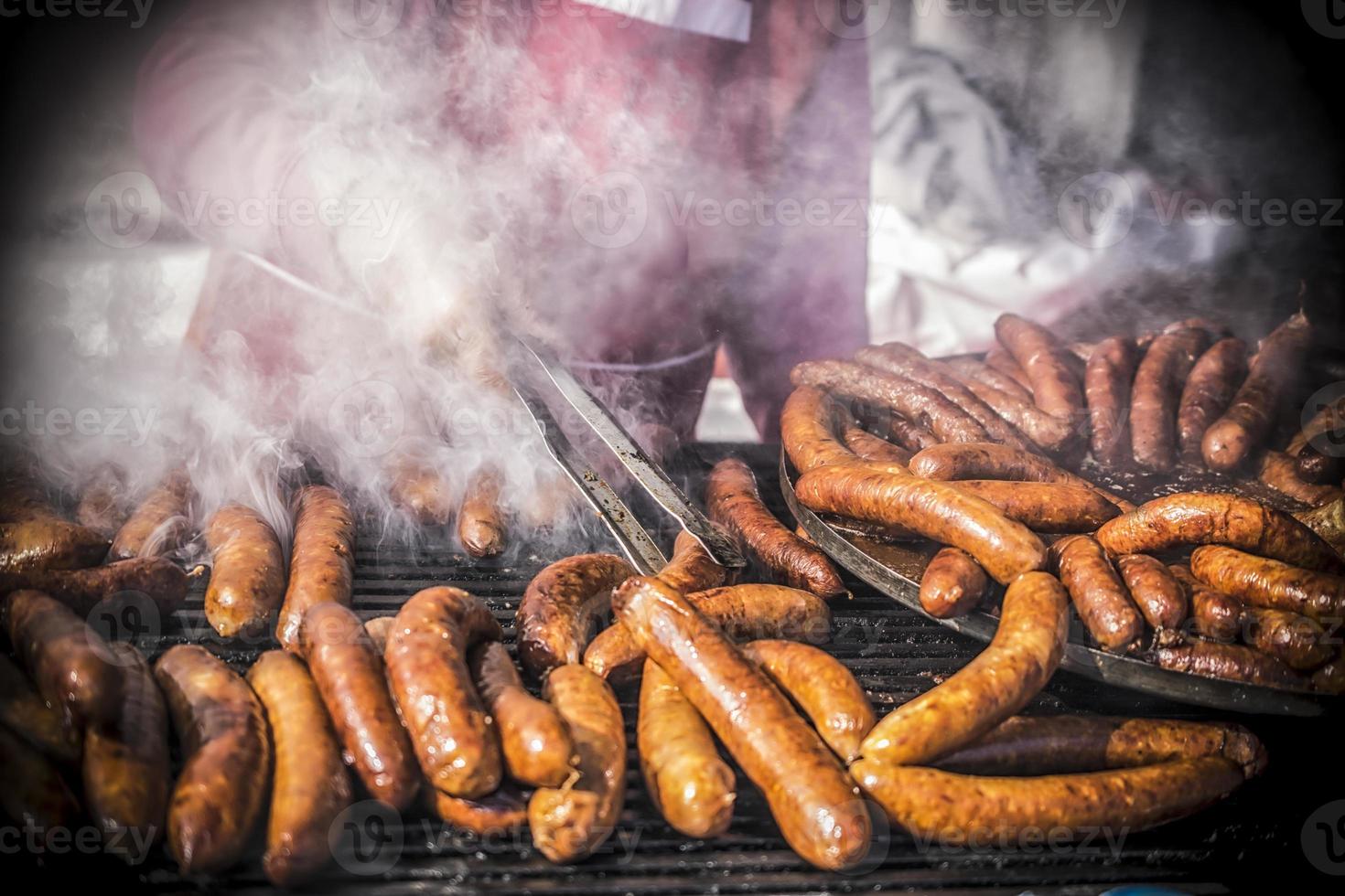 ein Nahansicht Aussicht von Hände von ein Mann Grillen hausgemacht Würste foto