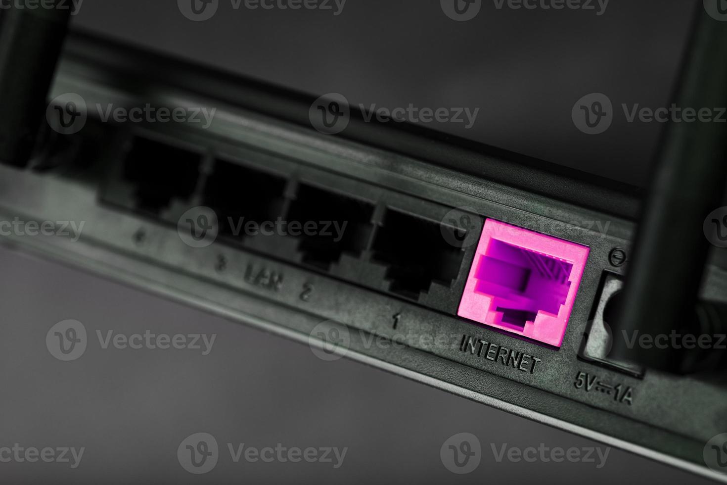 ein Rosa Patch Kabel ist eingefügt in das Routers W-lan Hafen zu Zugriff das Internet. Internet Verbindung Über ein Draht mit ein Router. foto