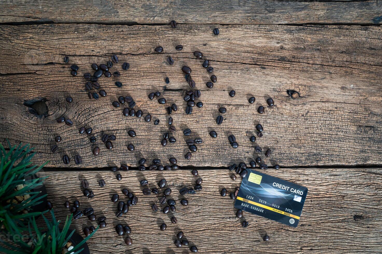 Kreditkarte und Kaffeebohnen auf dem Tisch foto