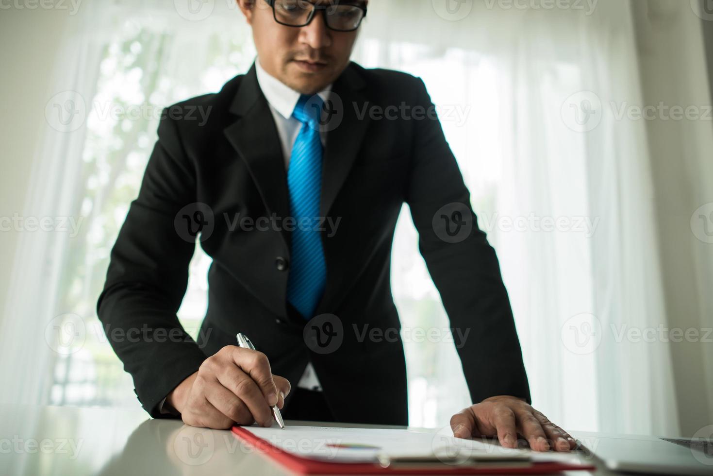 junger Geschäftsmann, der mit Laptop im Büro arbeitet foto