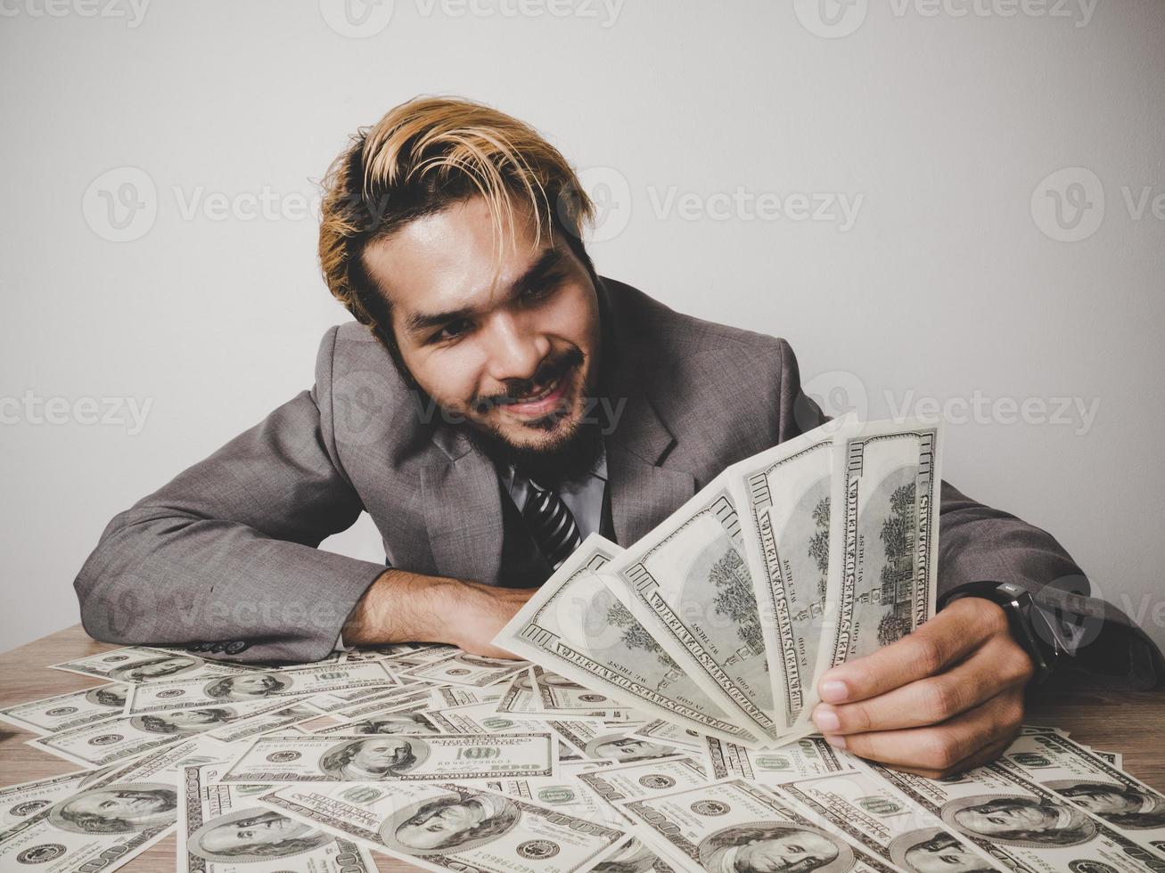 glücklicher Geschäftsmann mit Dollarbanknoten foto