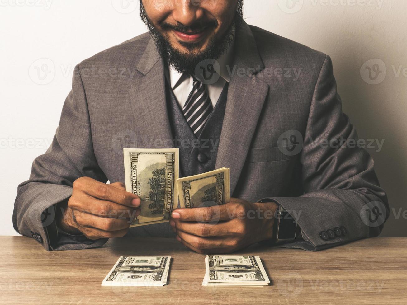 glücklicher Geschäftsmann mit Dollarbanknoten foto