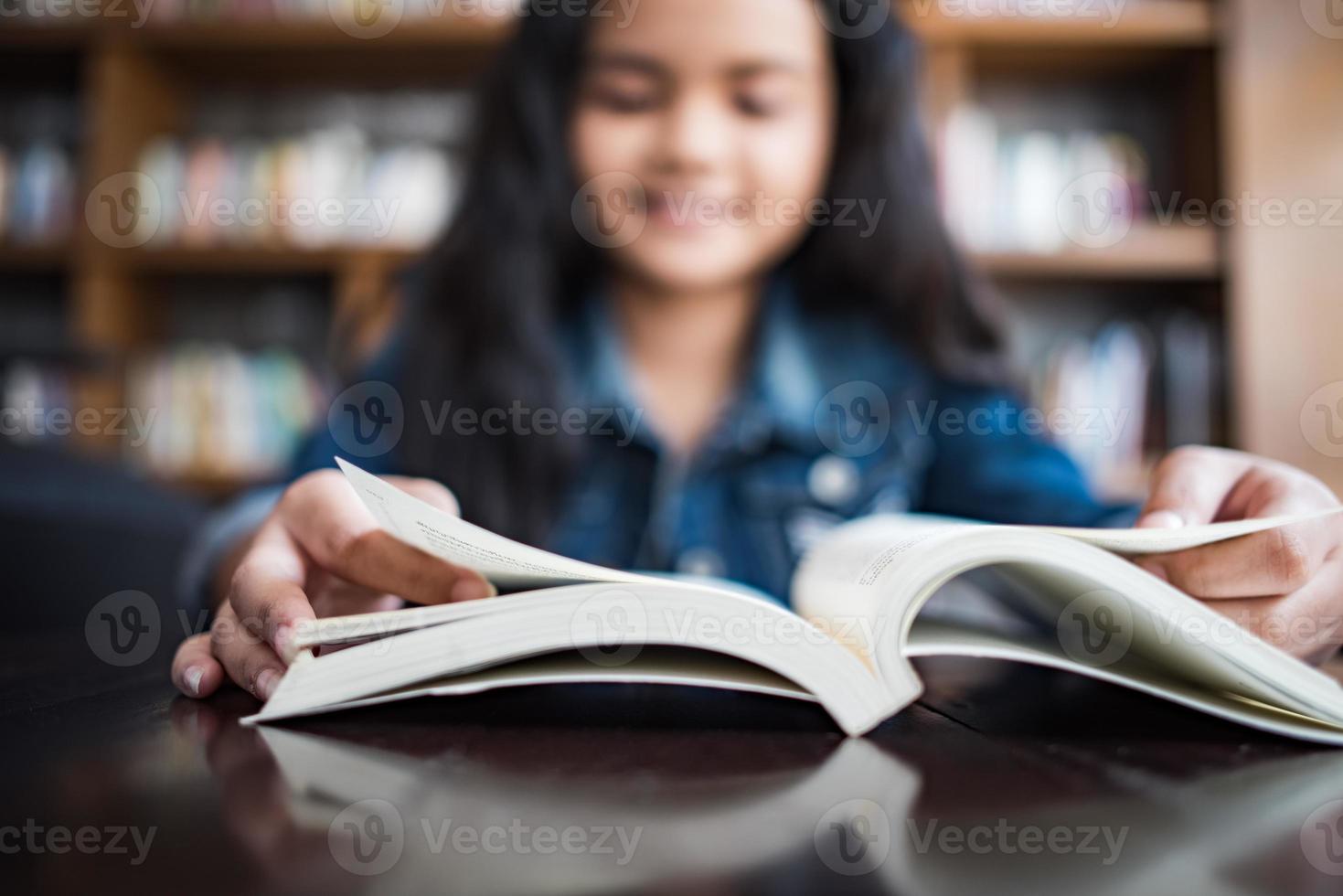 junge Frau, die ein Buch liest, das drinnen im städtischen Café sitzt foto