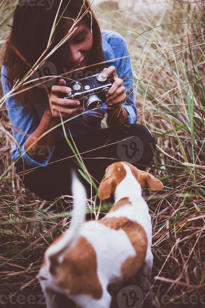 Hipster-Frau, die einen Schnappschuss ihres Hundes auf ihrer Vintage-Kamera macht foto