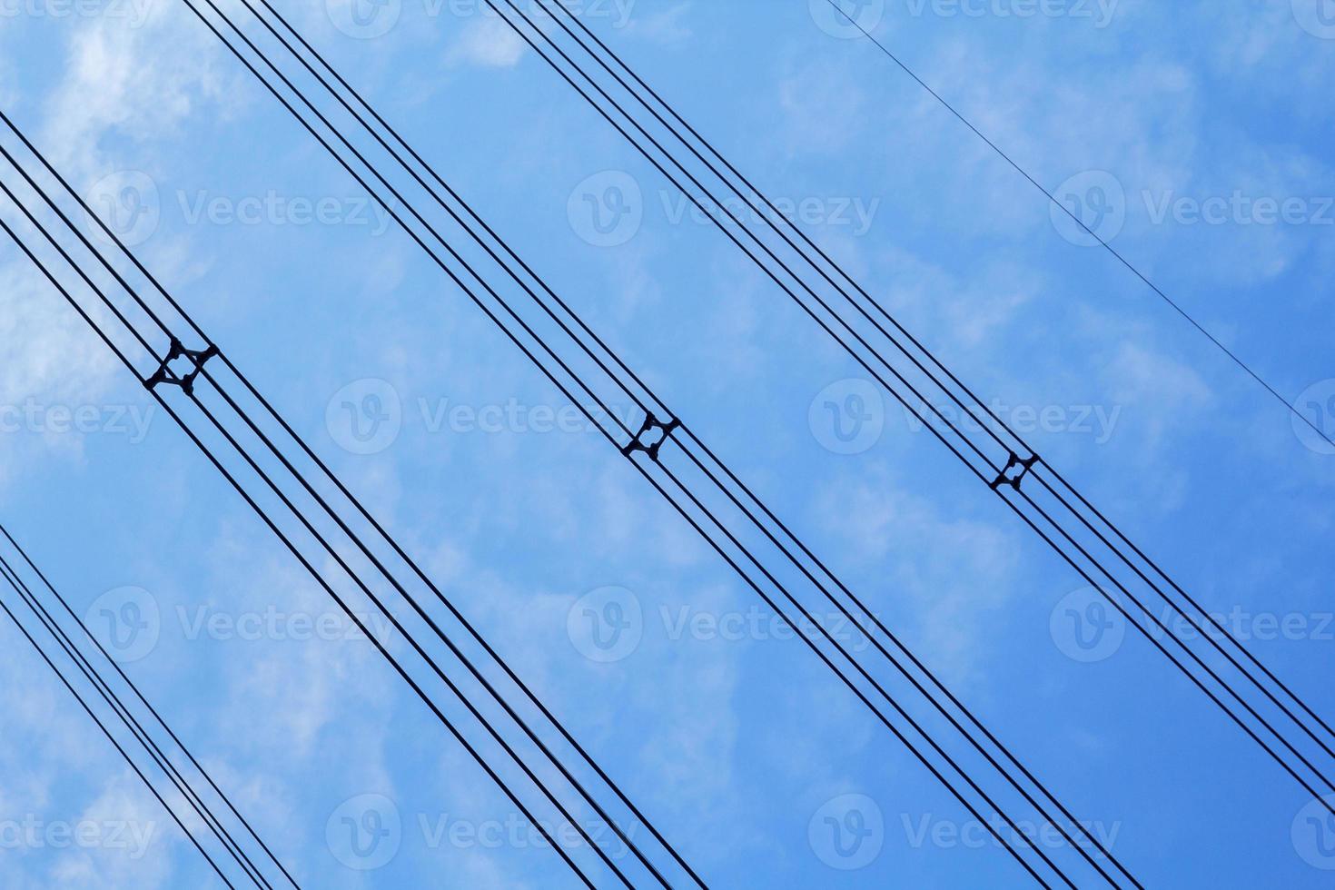 Hochspannung und isoliert Kabel suspendiert im das Blau Himmel sind Kabel Das tragen Elektrizität und Elektrizität zum Menschen und viele industriell Pflanzen und Unternehmen Das brauchen Elektrizität. foto