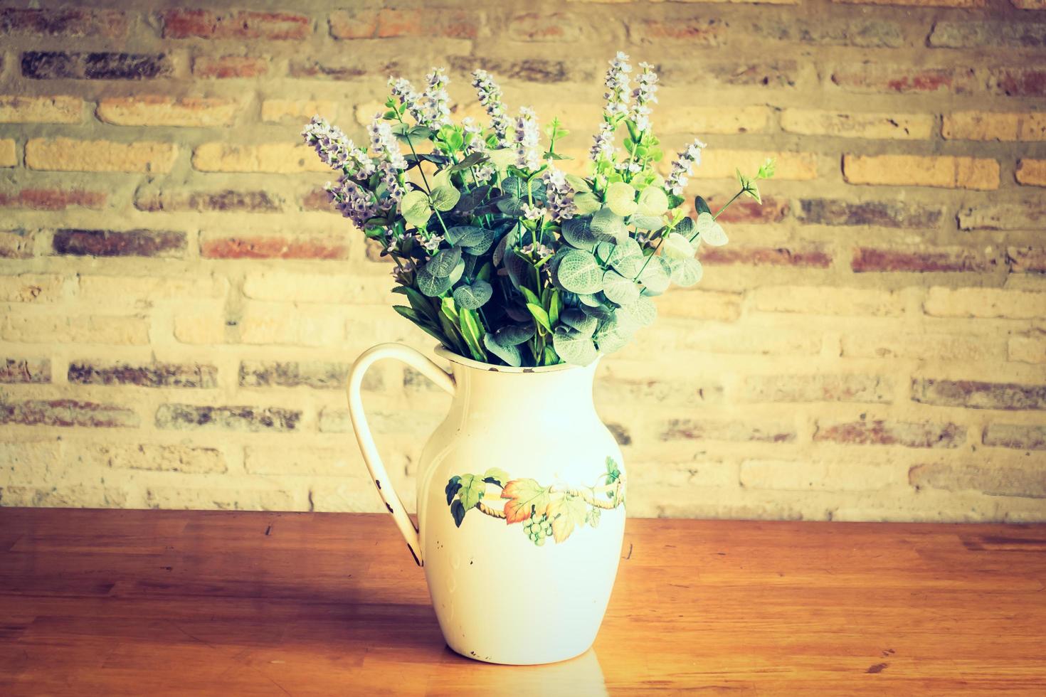 Vase und Blumen auf dem Tisch foto