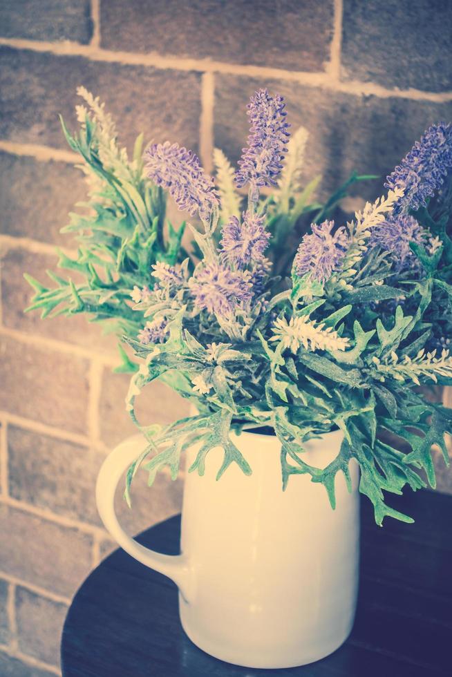 Vase und Blumen auf dem Tisch foto