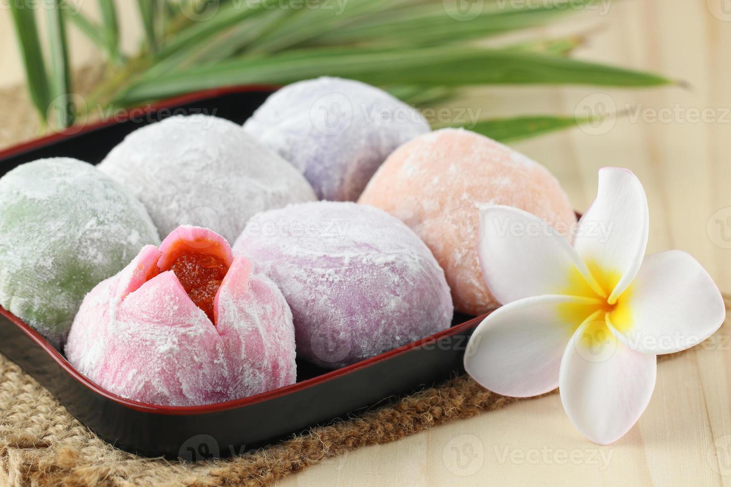 buntes japanisches Mochi-Dessert im schwarzen Tablett auf Holztisch foto