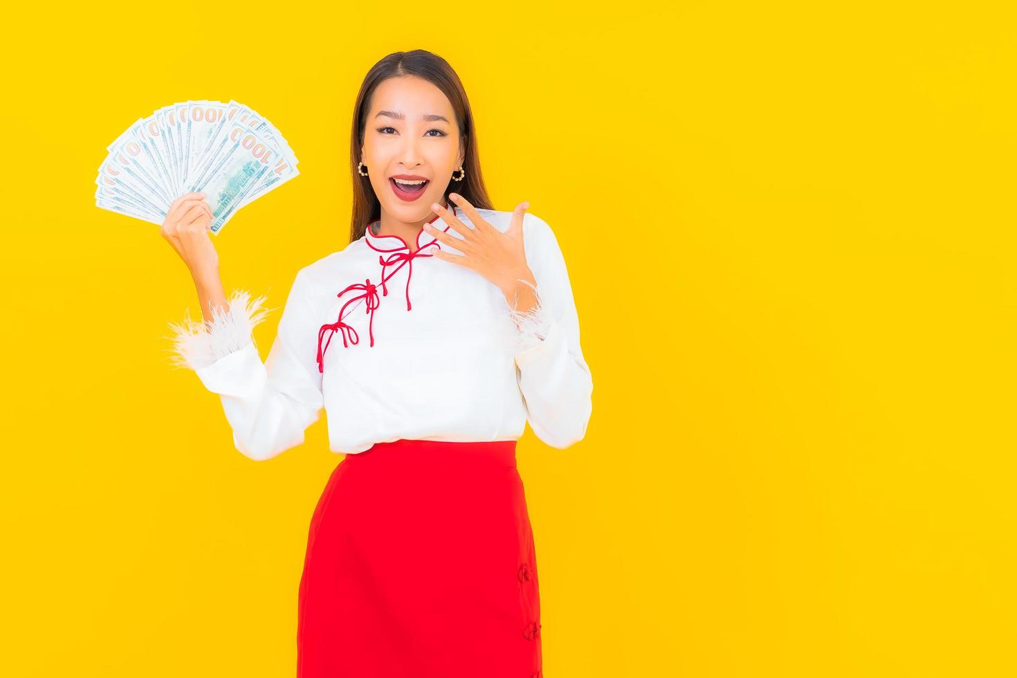 schöne junge asiatische Frau, die mit viel Geld sitzt foto