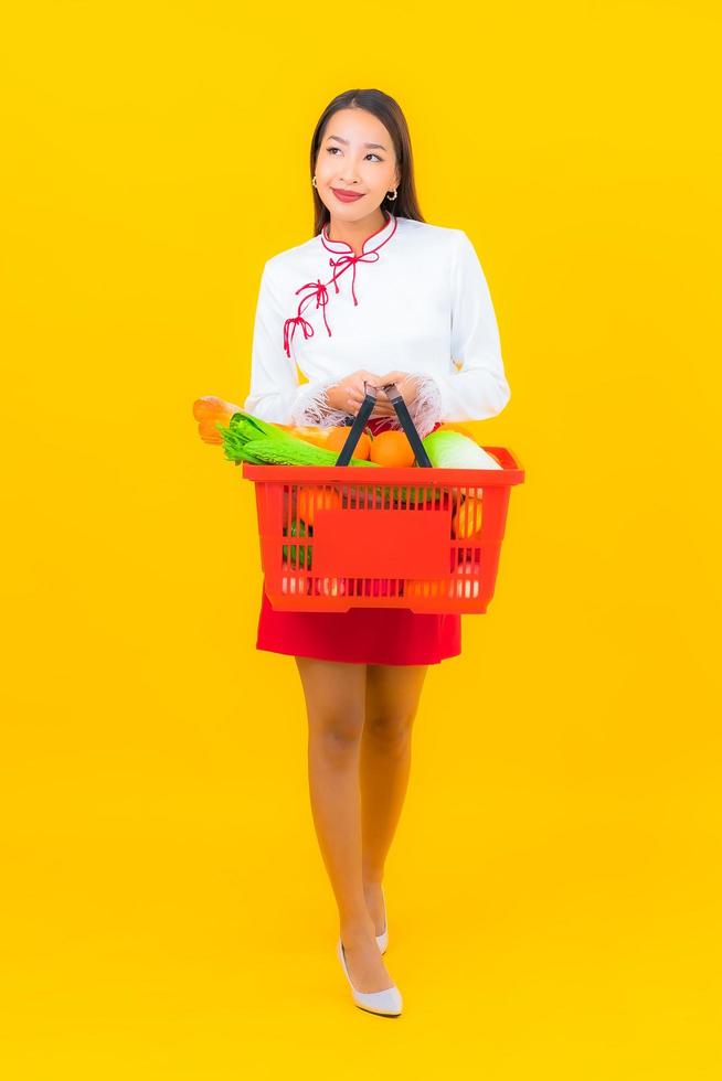 schöne junge asiatische Frau mit Einkaufskorb foto