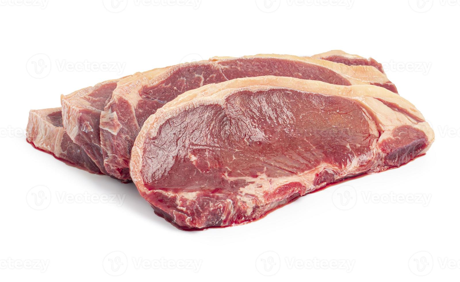 vier rohe Rindfleischsteaks auf weißem Hintergrund foto