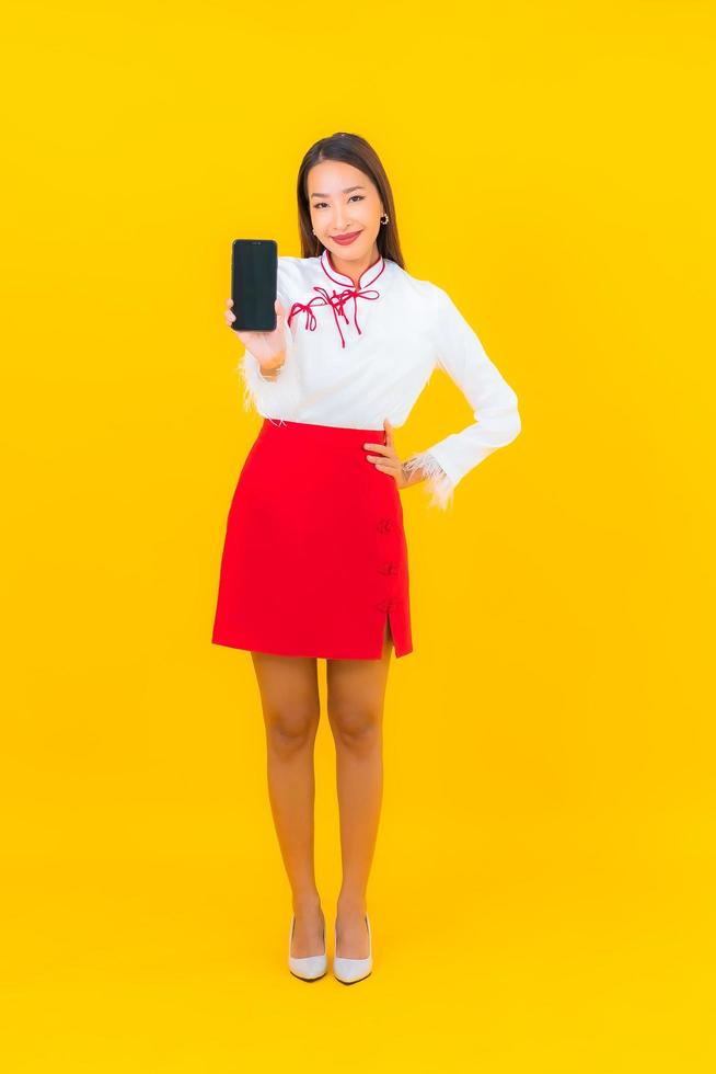 junge asiatische Frau mit intelligentem Handy foto