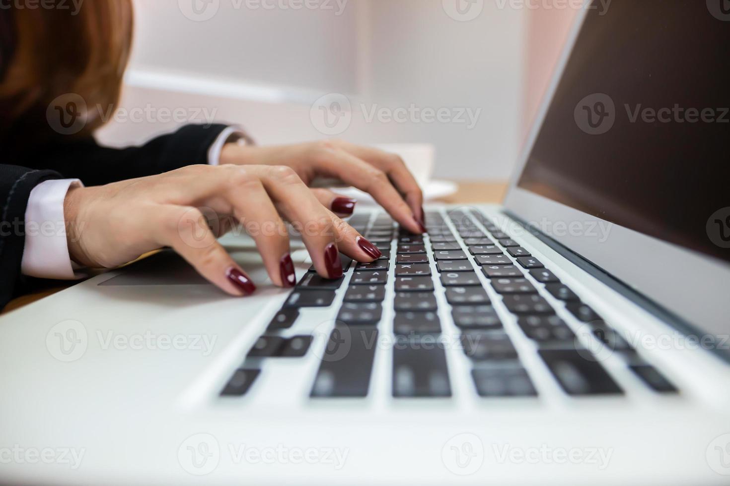 Frau, die auf einem Laptop tippt foto