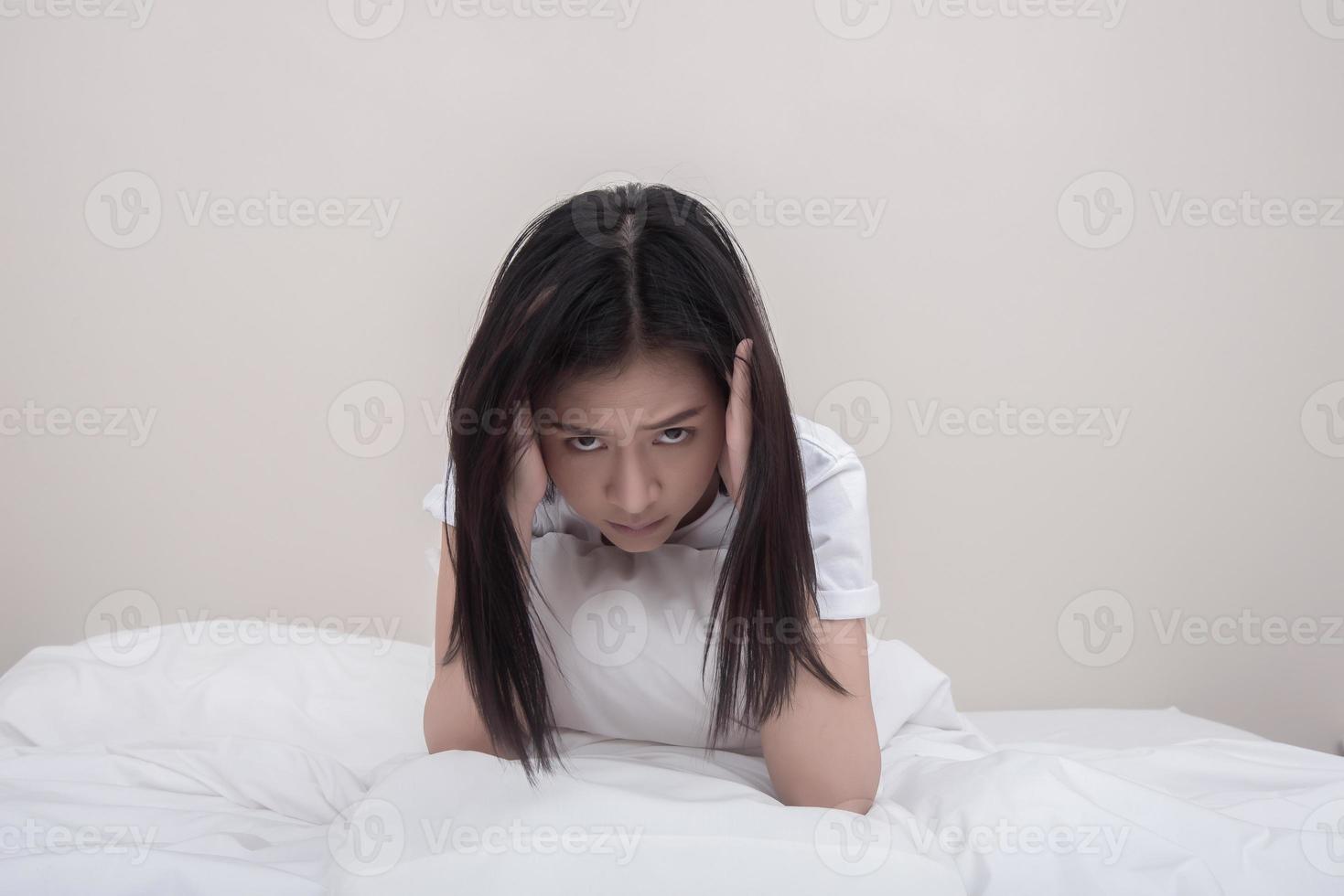 depressive junge Frau im Bett sitzen foto