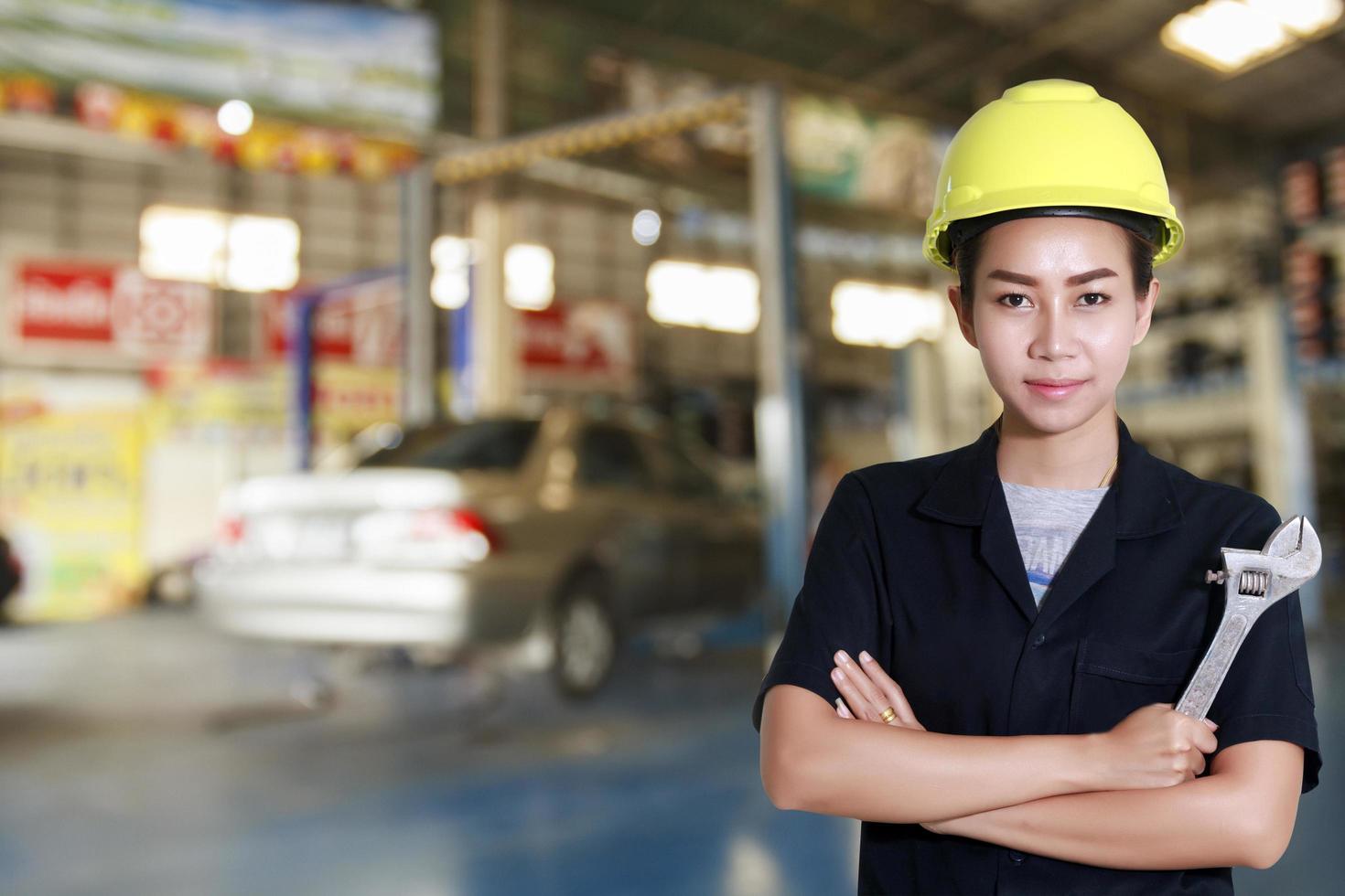 asiatische Ingenieurin, die einen Schraubenschlüssel in der Hand hält foto