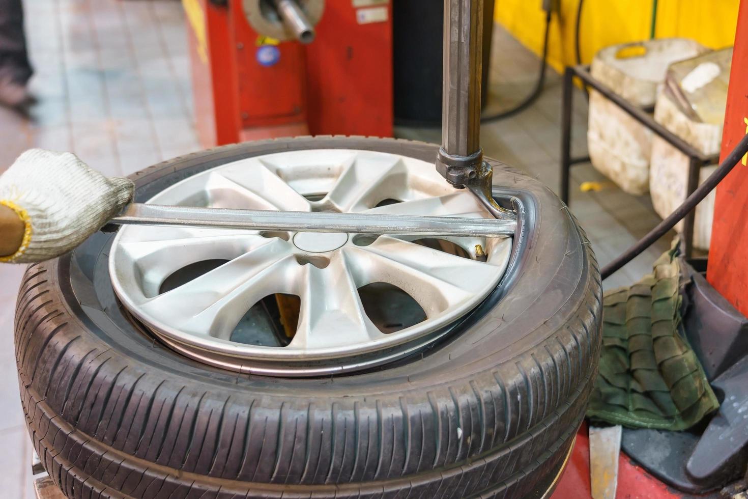 Nahaufnahme des Mechanikerwechsels des Autoreifens in der Werkstatt foto