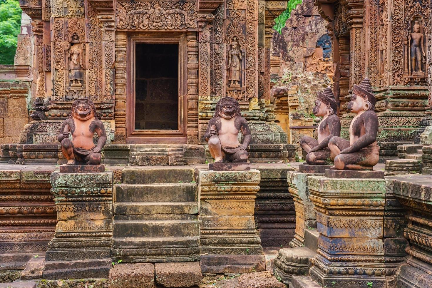 Löwen- und Affenstatuen im Banteay Srei-Tempel aus rotem Sandstein, Kambodscha foto