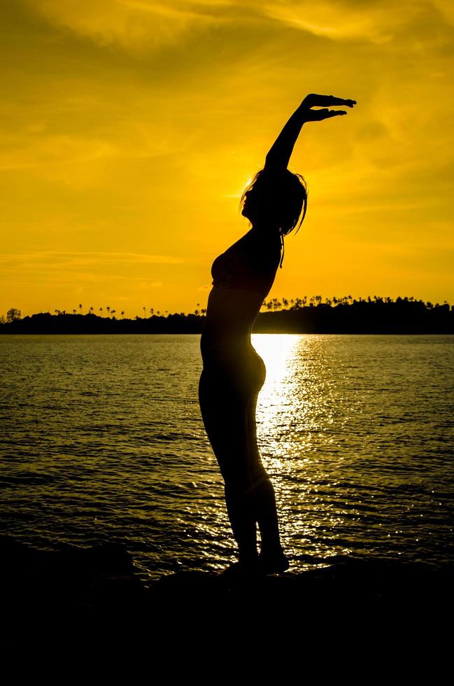 Porträt einer jungen Frau als Silhouette am Meer foto