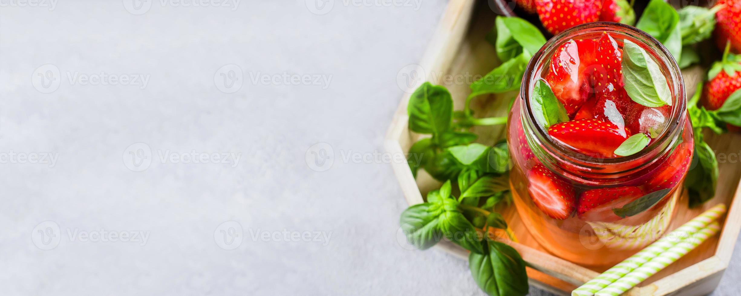 Sommer- Essen und trinken. Limonade mit Erdbeere und Basilikum im Mason Krug auf hölzern Tablett auf Tabelle foto