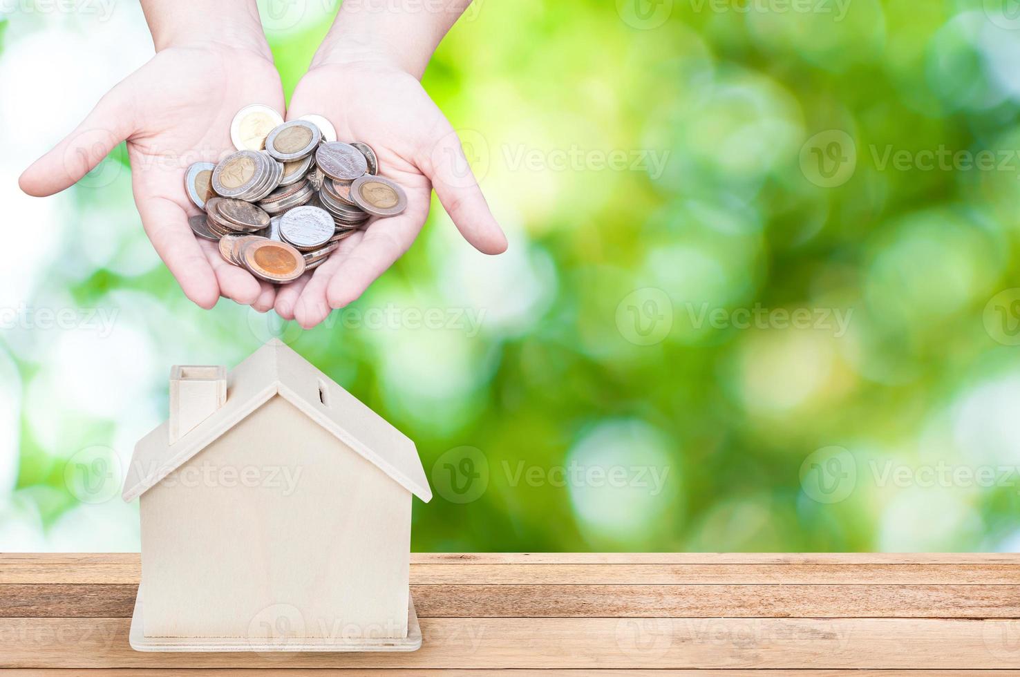 Frau Hand halten Münzen Haus Bank speichern Geld, Grün Natur Hintergrund. Investition und speichern Konzept foto