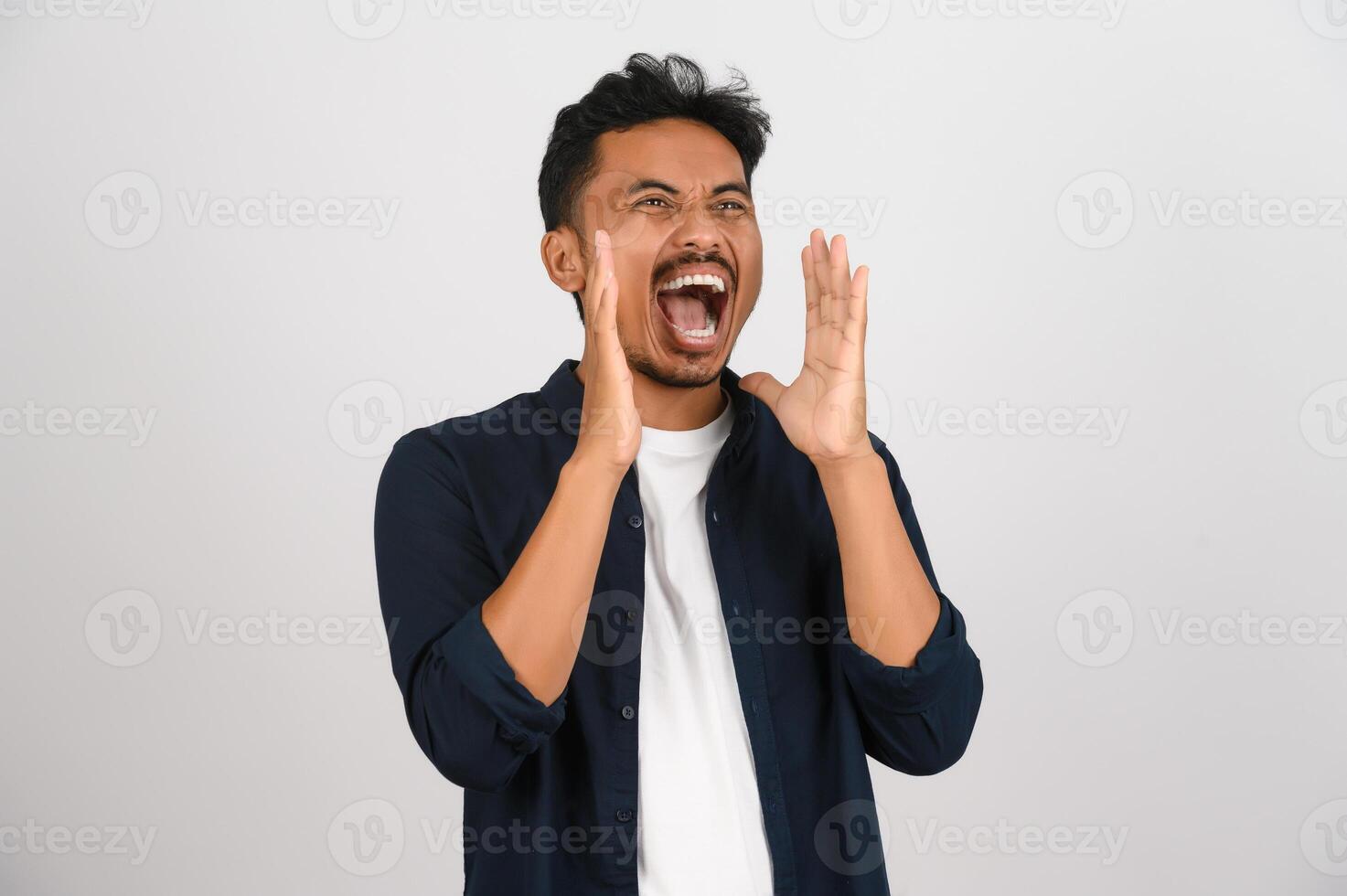 Porträt von jung asiatisch Mann im Blau Hemd schreien Geschichte oder Herstellung Ankündigung isoliert auf Weiß Hintergrund foto