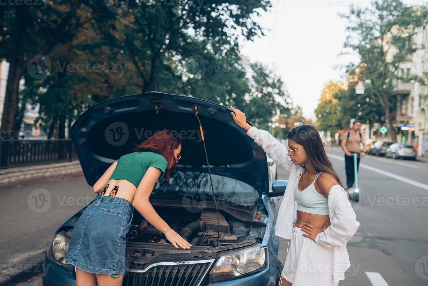 Zwei Frauen mit kaputtem Auto auf der Straße. offene Haube 20171435  Stock-Photo bei Vecteezy