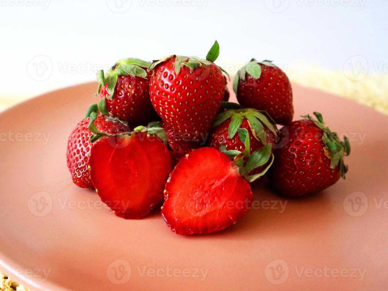 frisch Erdbeeren gestapelt auf ein Rosa Teller foto