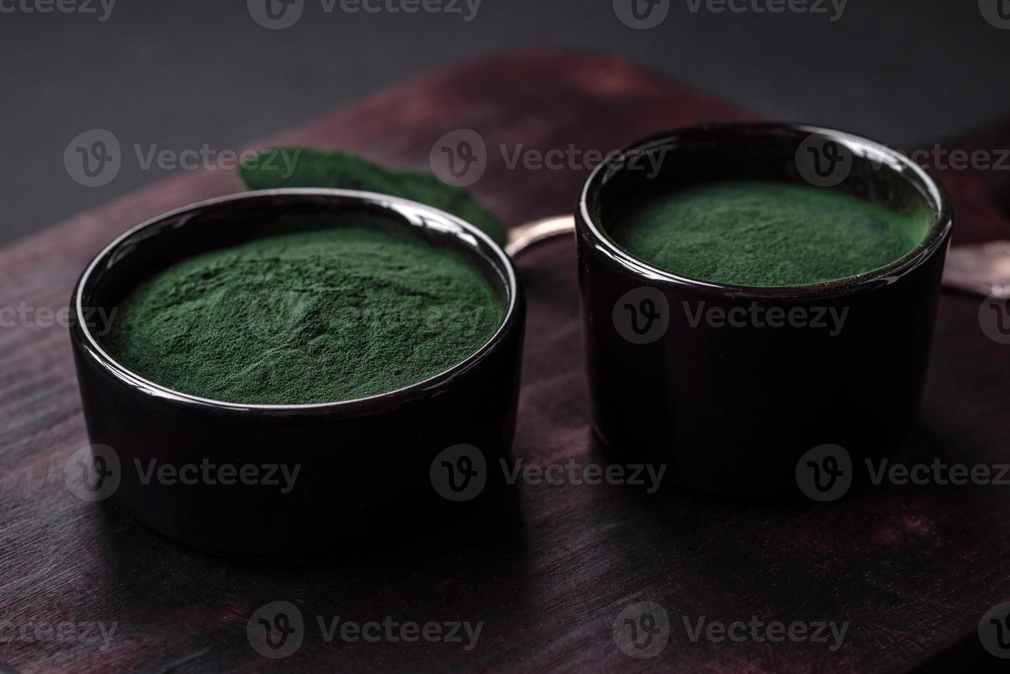 würzen, Grün Farbe Spirulina im das bilden von Pulver im ein schwarz Schüssel foto