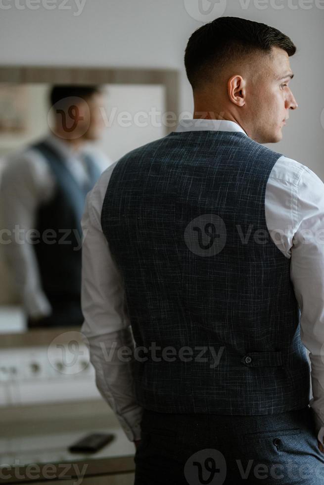 Porträt des Bräutigams in einem hellgrauen Anzug foto