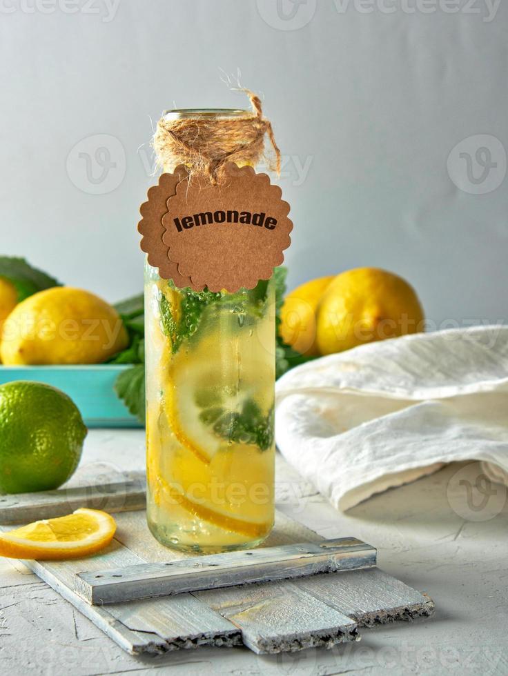 limonade mit zitronen, minzblättern, limette in einer glasflasche foto