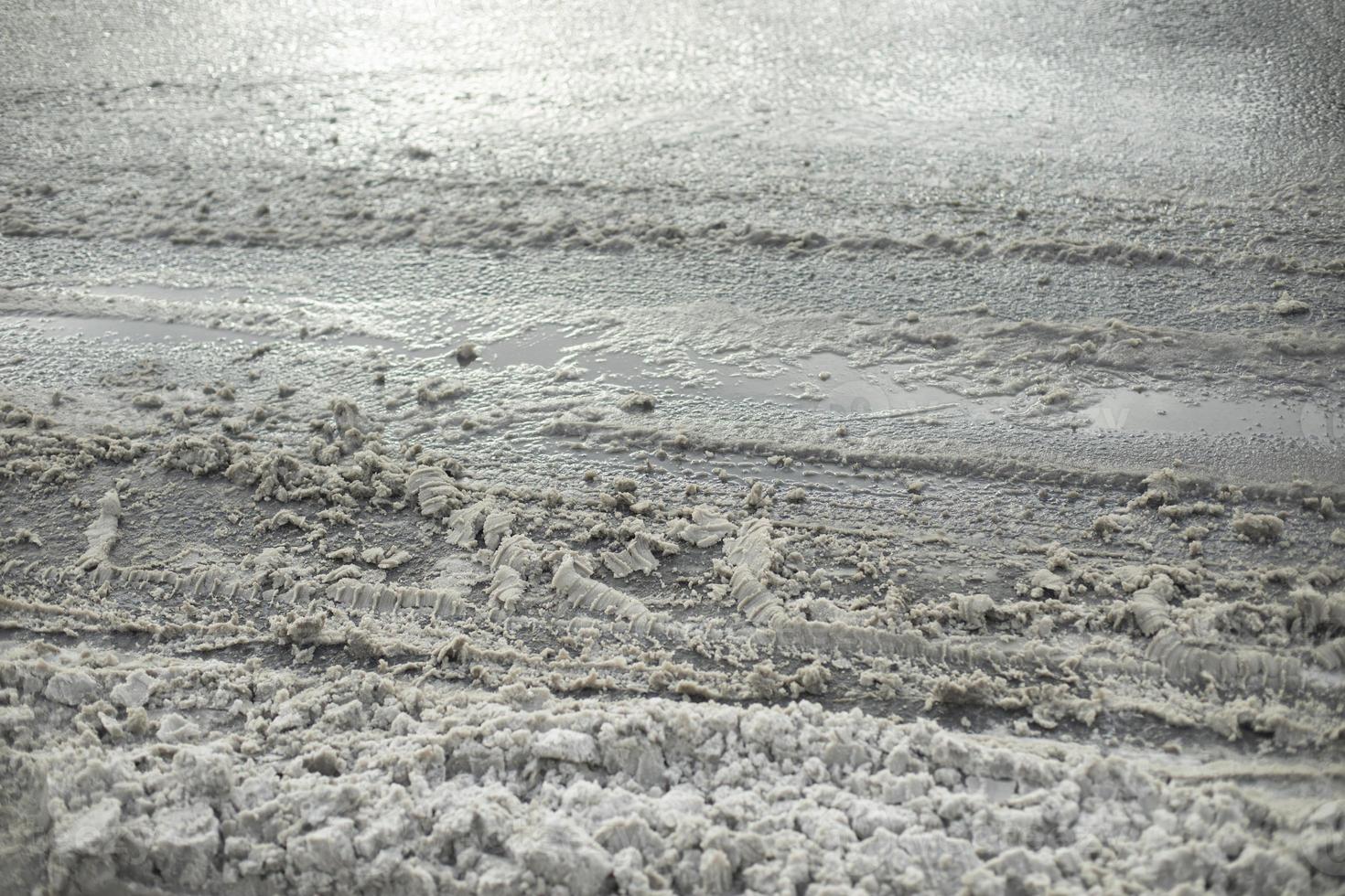 geschmolzen Schnee auf Straße. geschmolzen Dreck. Asphalt Einzelheiten im Winter. foto