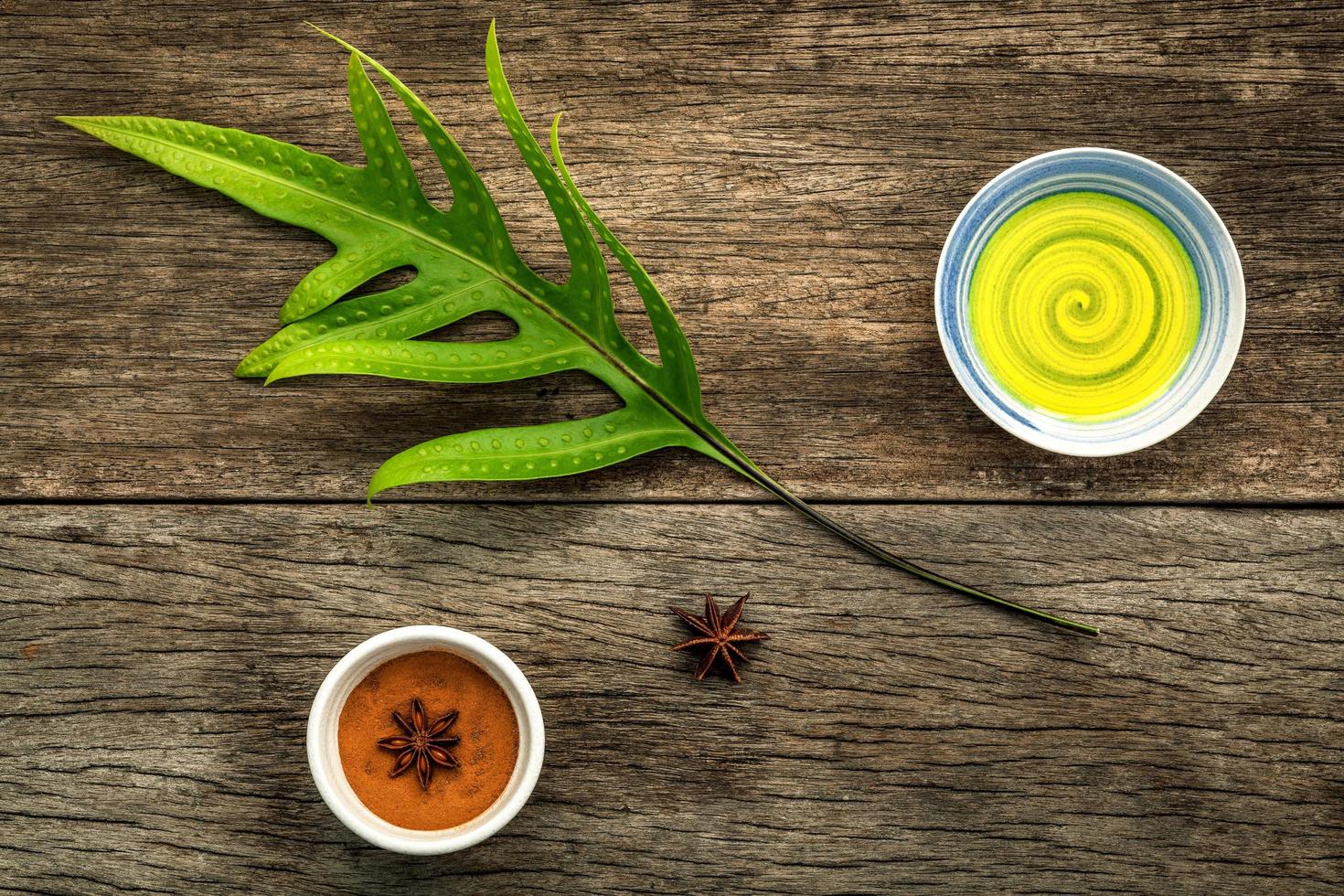 grüne Blätter und mit aromatischem Öl und Sternanis auf einem rustikalen Hintergrund foto