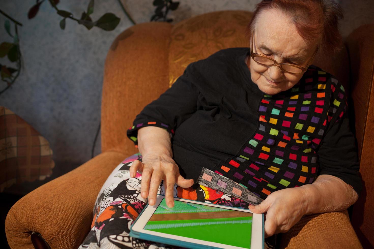 ältere Frau, die das Internet auf einem Tablet surft foto