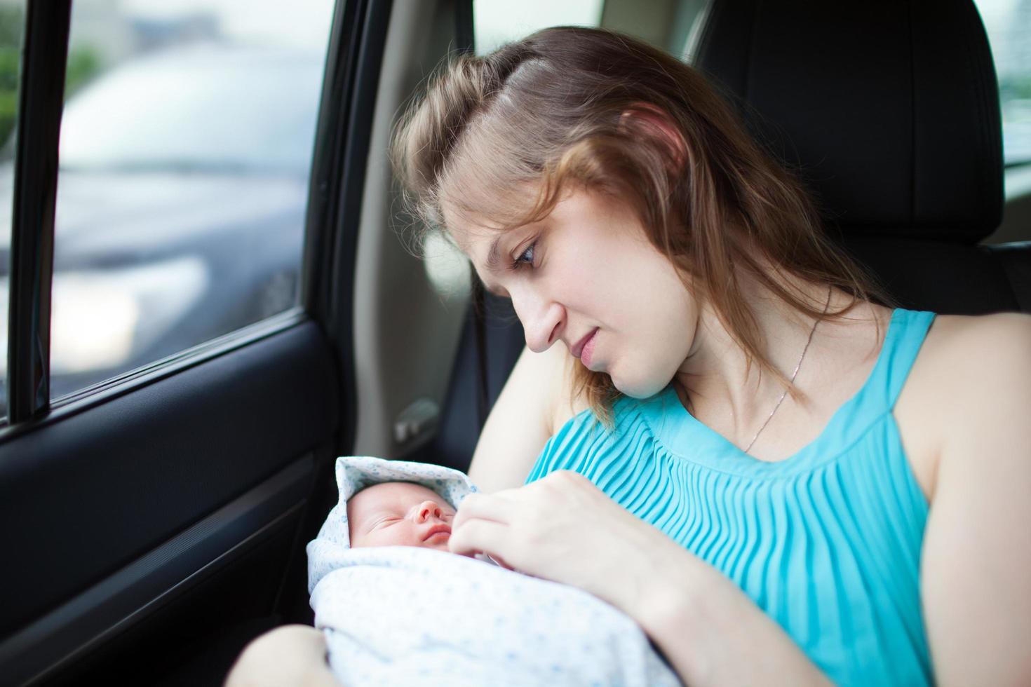 Mutter mit Neugeborenem im Auto foto