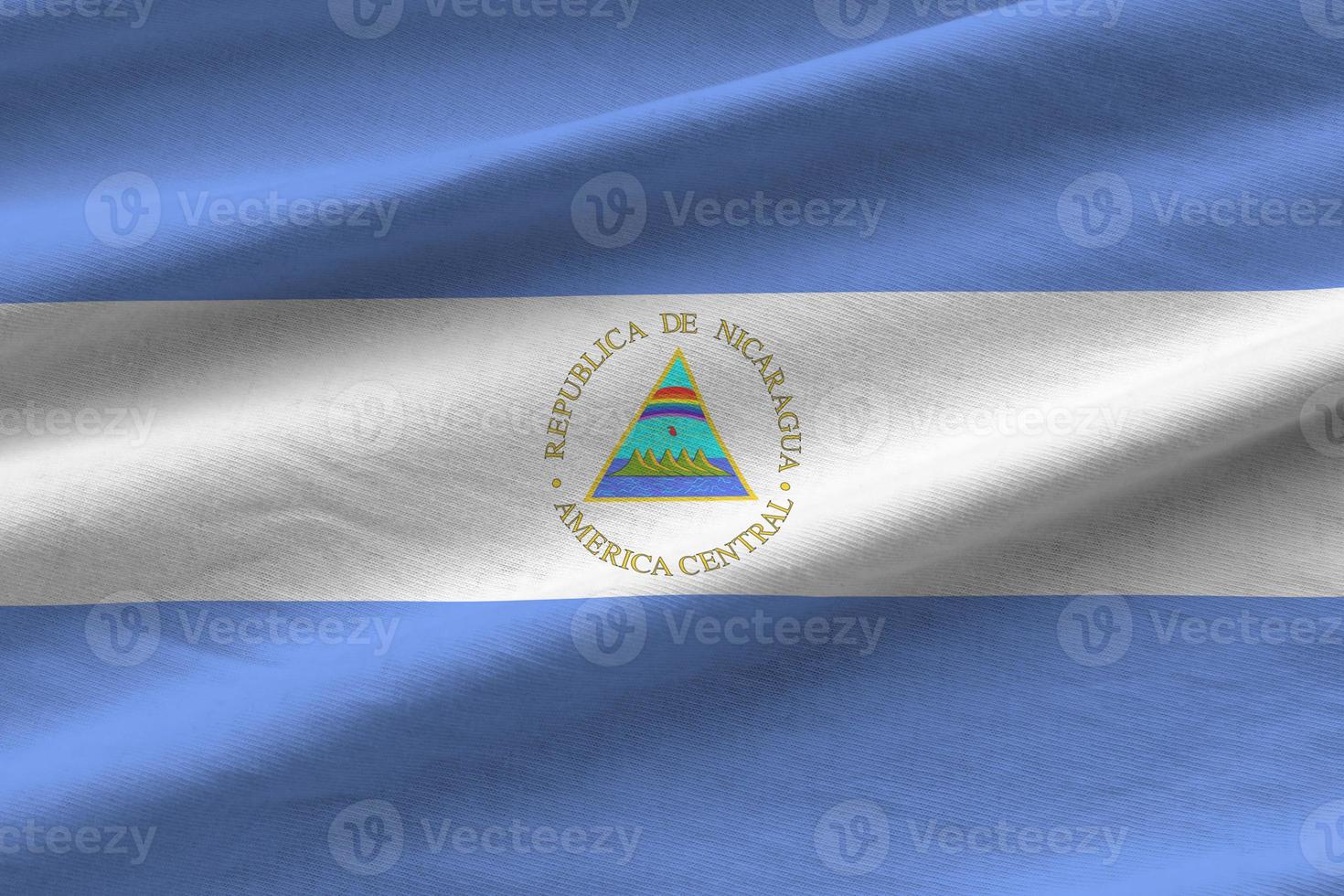 Nicaragua-Flagge mit großen Falten, die im Innenbereich unter dem Studiolicht wehen. die offiziellen symbole und farben im banner foto
