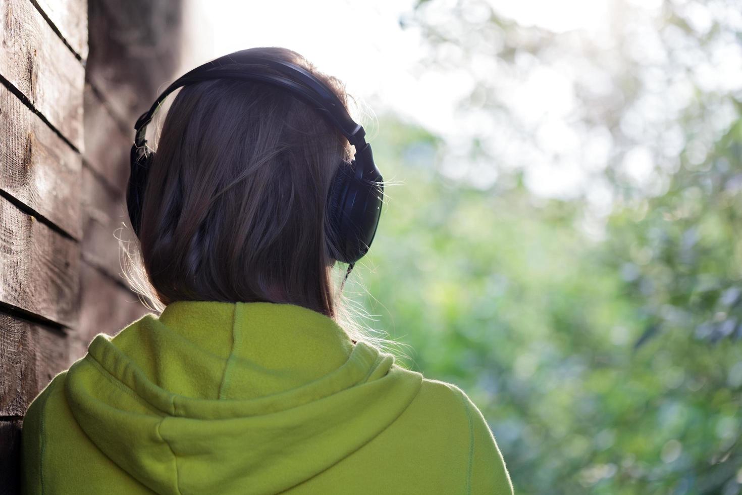 Frau, die draußen Musik hört foto