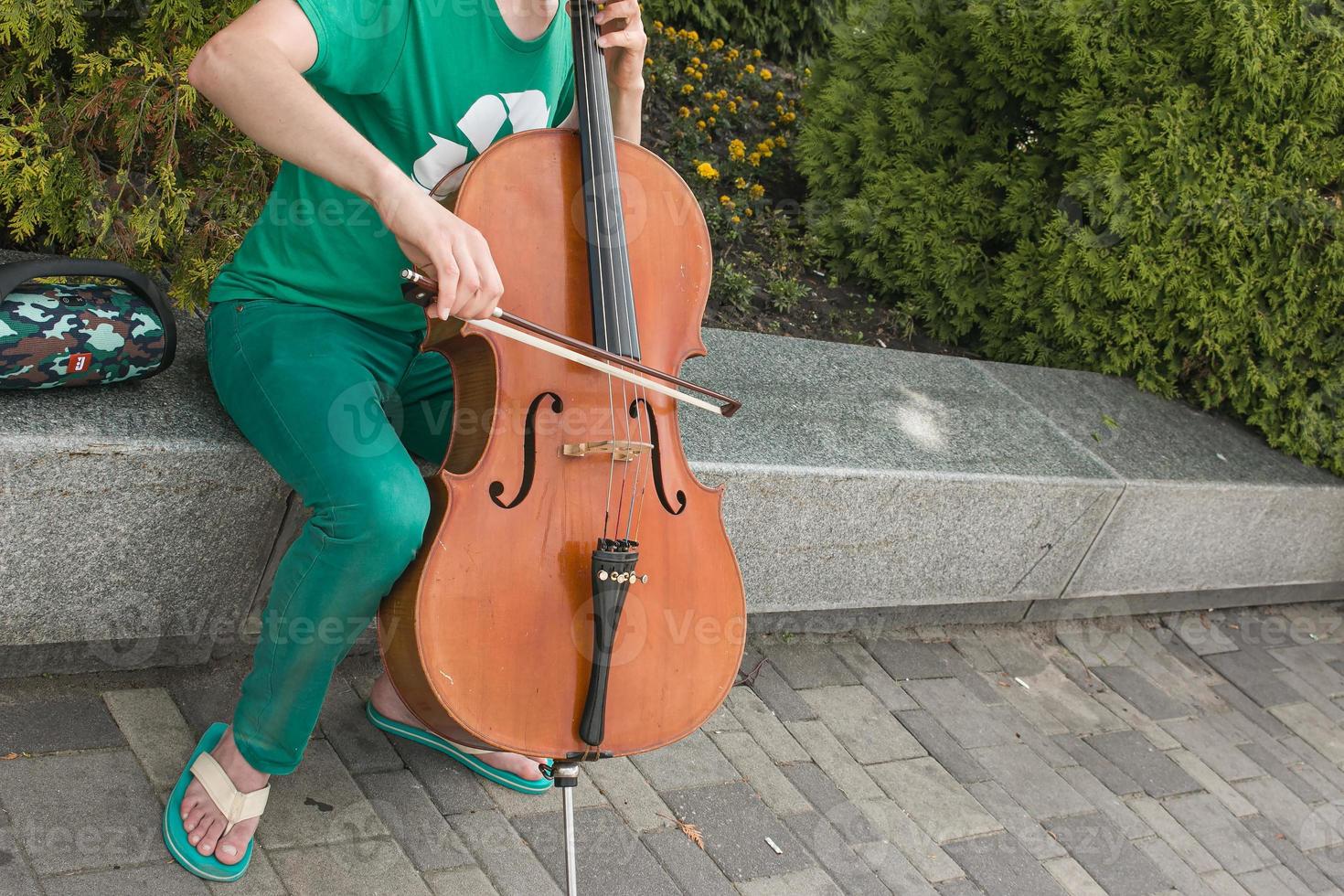 Detail von ein Mann spielen das hölzern Cello Reiben das Saiten mit das Bogen zu erhalten das Anmerkungen von ein klassisch Musik- Stück. foto