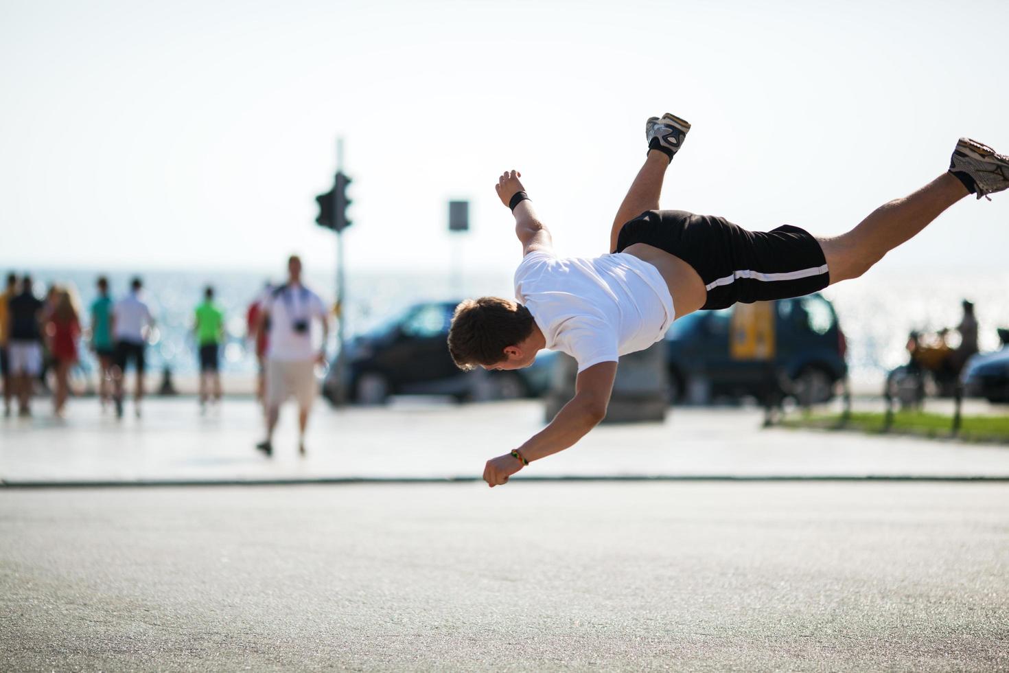 junger Mann macht einen Salto foto