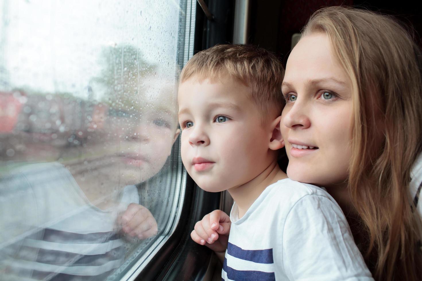 Mutter und Sohn schauen aus einem Zugfenster foto