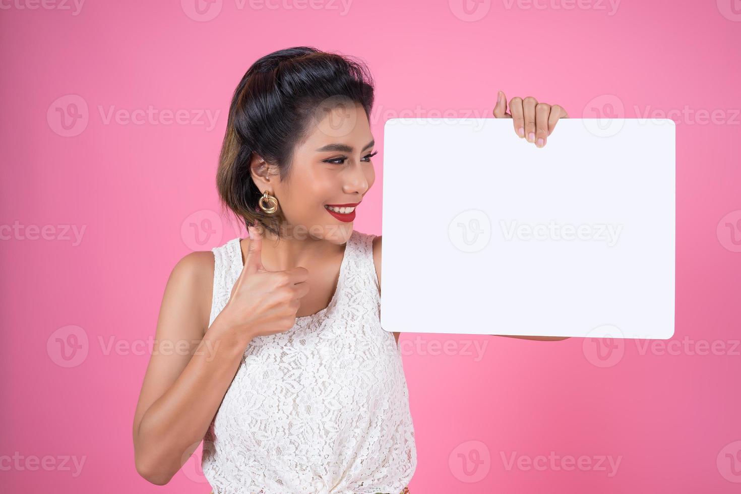 Porträt einer modischen Frau, die ein weißes Banner anzeigt foto