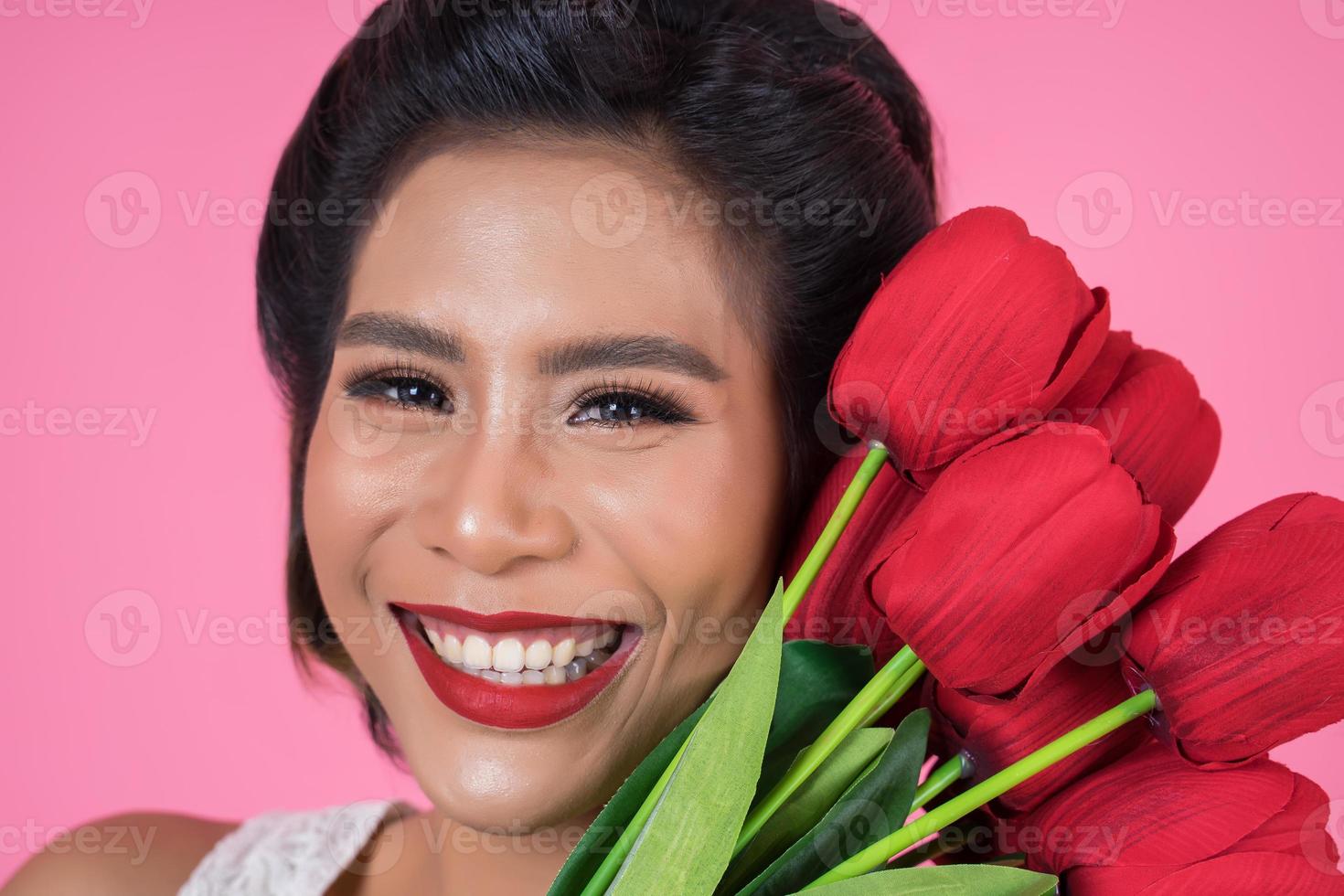 Porträt einer schönen Frau mit Strauß roter Tulpenblumen foto