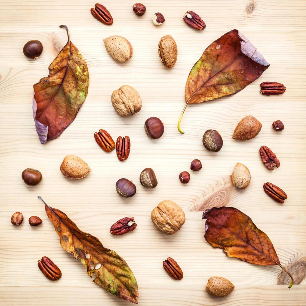 getrocknete Blätter und Nüsse auf einem hölzernen Hintergrund foto