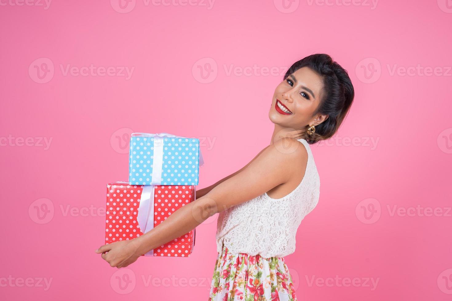 schöne glückliche Frau mit Überraschungsgeschenkboxen foto